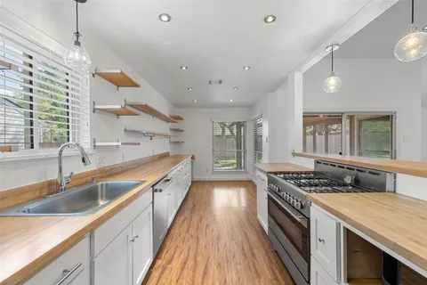 a view of a room with wooden floors and ceiling fan