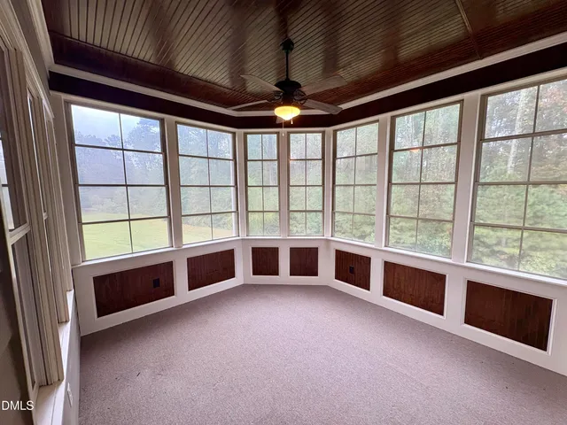 an empty room with windows and chandelier