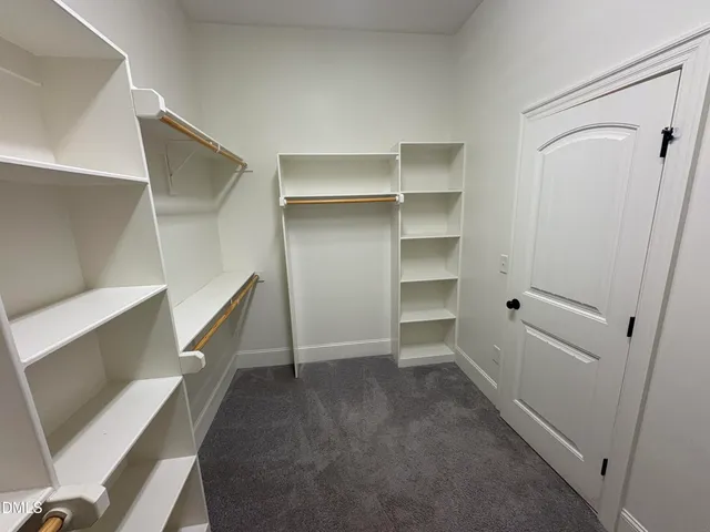 a view of an empty room with a fireplace and stairs