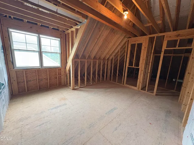 an empty room with a ceiling fan and a window