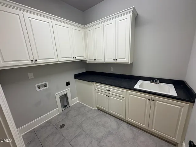 a kitchen with granite countertop white cabinets and sink
