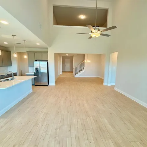 a view of an empty room and kitchen view