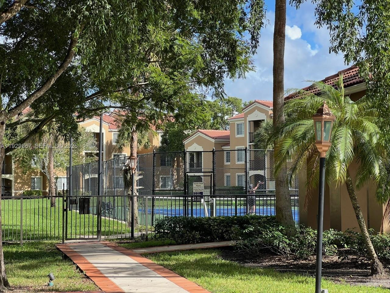 8000 North Nob Hill Road, Unit 204 Tamarac, FL 33321 - Photo 15 of 27 a view of a white house in a big yard with palm trees