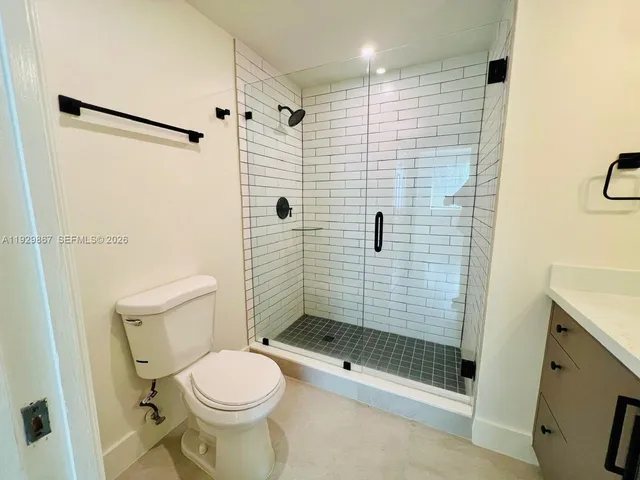 a bathroom with a shower a toilet and a sink