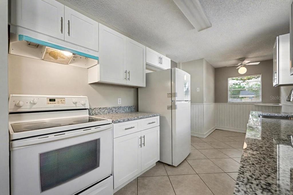 173 North Ridgewood Avenue Ormond Beach, FL 32174 - Photo 14 of 33 a kitchen with white cabinets and white appliances
