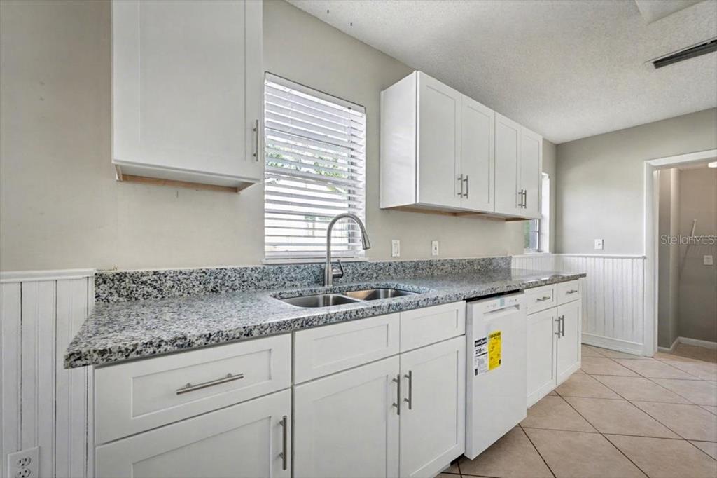 173 North Ridgewood Avenue Ormond Beach, FL 32174 - Photo 16 of 33 a kitchen with granite countertop cabinets stainless steel appliances a sink and a window