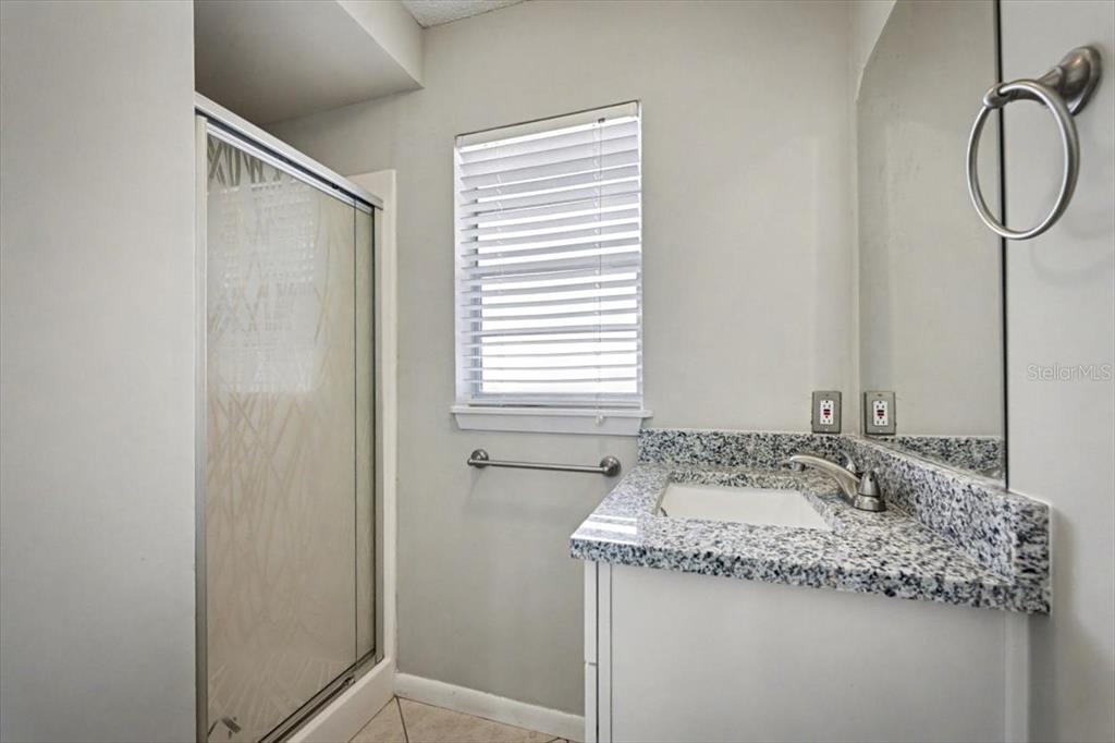 173 North Ridgewood Avenue Ormond Beach, FL 32174 - Photo 23 of 33 a bathroom with a granite countertop sink and a mirror