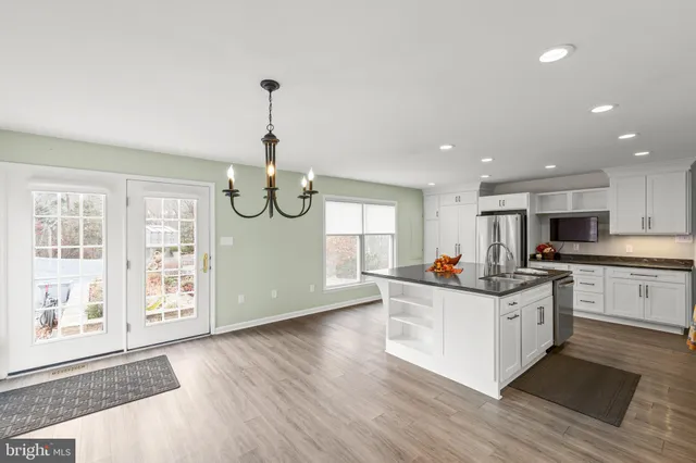 a kitchen with stainless steel appliances granite countertop a stove and wooden floors