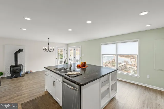 a kitchen with granite countertop a sink and a stove top oven