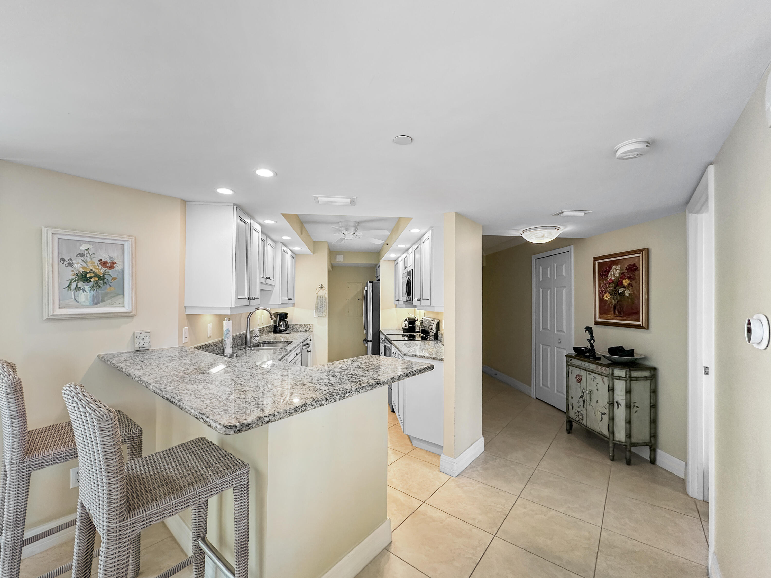 3000 North Ocean Drive, Unit 4F Riviera Beach, FL 33404 - Photo 6 of 56 a kitchen with kitchen island granite countertop a stove a sink a table and chairs