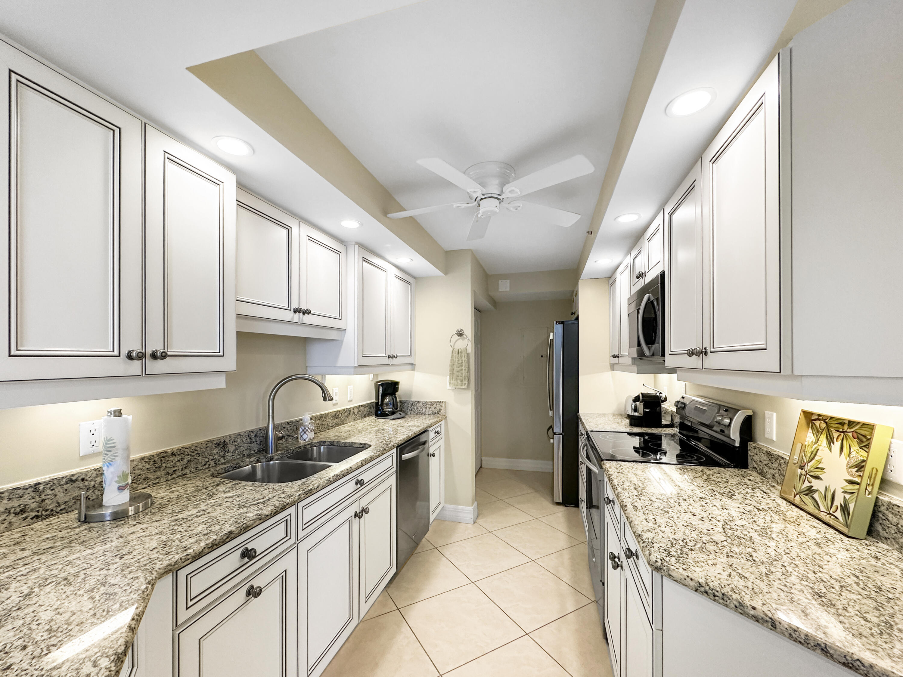 3000 North Ocean Drive, Unit 4F Riviera Beach, FL 33404 - Photo 7 of 56 a kitchen with granite countertop a sink a stove and cabinets