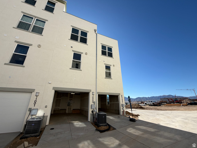 10999 South Freestone Road, Unit 111 South Jordan, UT 84009 - Photo 8 of 13 Rear view of property with stucco siding, a mountain view, a garage, and concrete driveway
