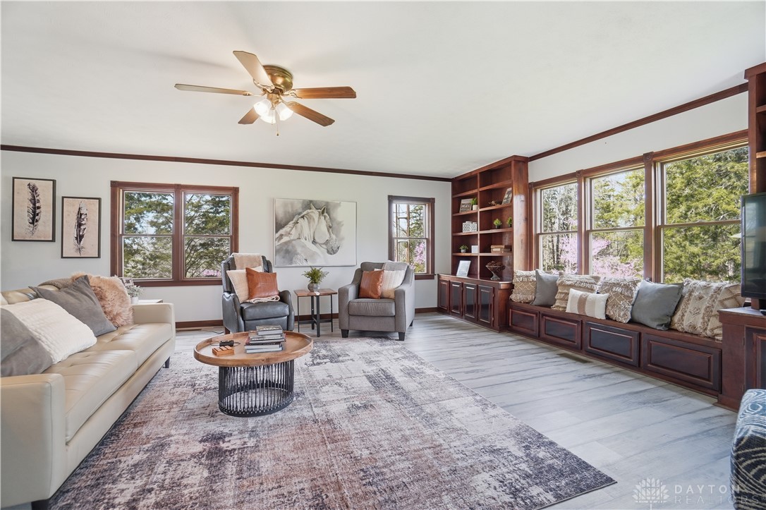 7553 Coffin Station Road Springfield, OH 45502 - Photo 25 of 95 This bright living area features built-in storage and large windows, offering comfort and style.