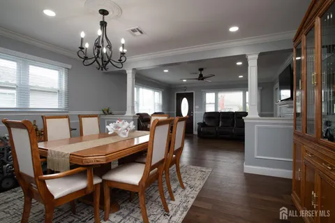 a view of a dining room with furniture a chandelier and wooden floor