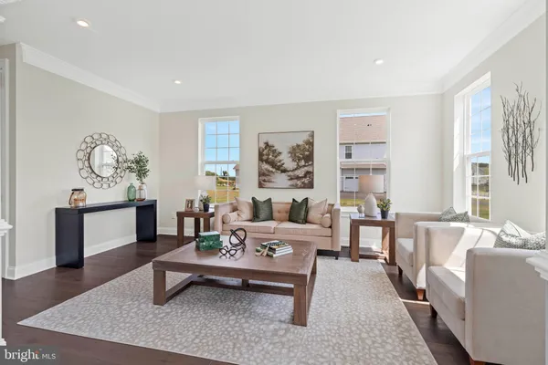a living room with furniture a flat screen tv and a window