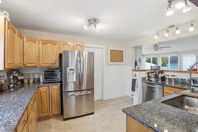 a large kitchen with granite countertop a sink stainless steel appliances and cabinets