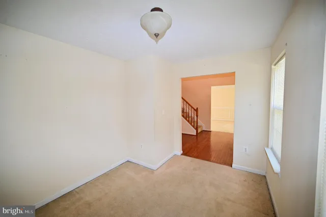 a living room with stainless steel appliances furniture a flat screen tv and a refrigerator