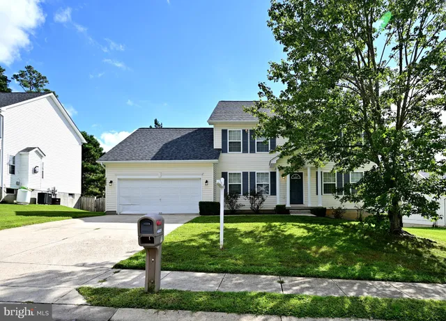 a front view of a house with a yard and a garage