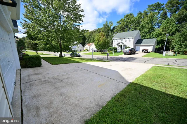 a view of a house with a big yard and large trees