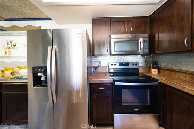 a kitchen with a refrigerator stove and cabinets