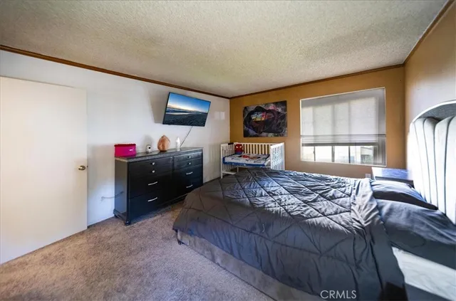 a bedroom with a bed window and a flat screen tv