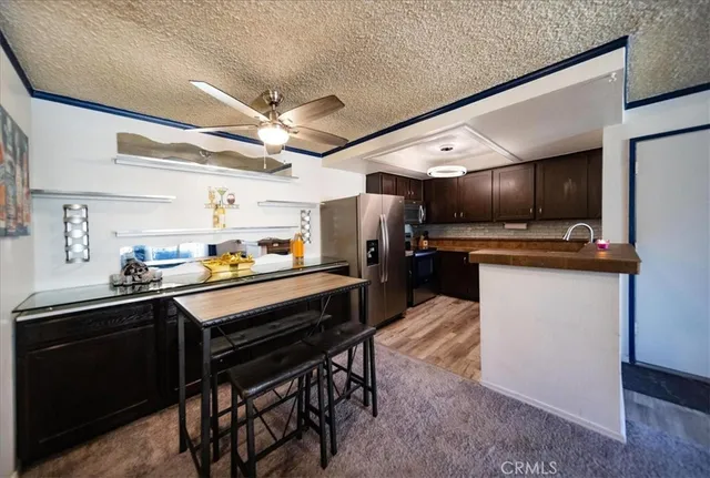a kitchen with kitchen island stainless steel appliances a sink stove and refrigerator