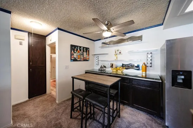 a room with stainless steel appliances kitchen island granite countertop furniture and a refrigerator