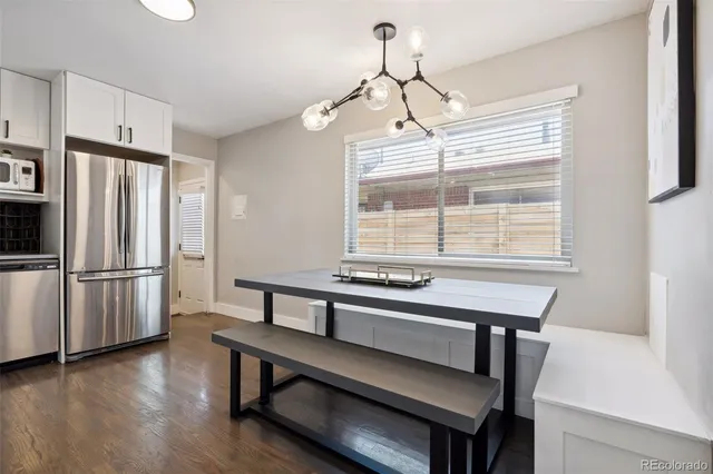 a kitchen with stainless steel appliances a table chairs and wooden floor