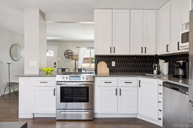 a kitchen with white cabinets and appliances