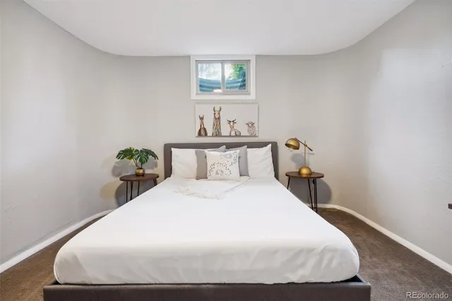 a bedroom with a bed and a painting on the wall