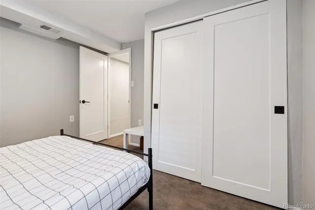 a backyard of a house with wooden chairs and a potted plant