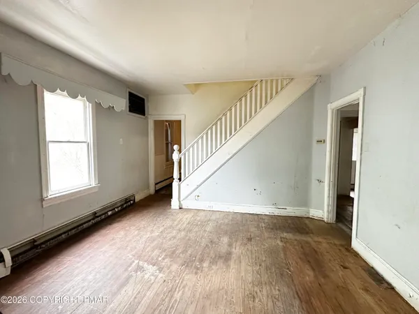 a view of a room with wooden floor and window