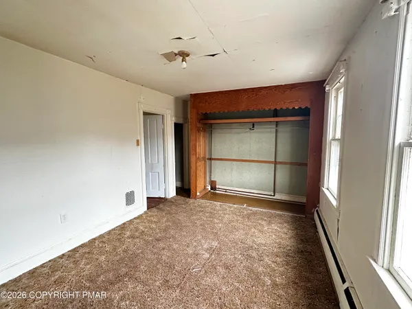 a view of an empty room with a fireplace and a window