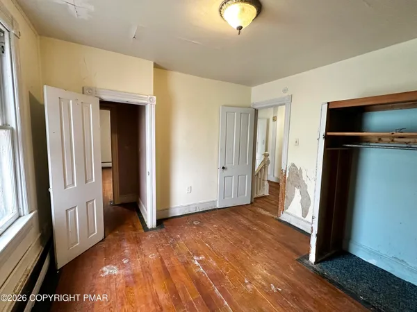 a view of a big room with wooden floor and windows