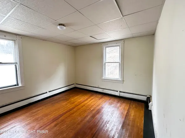 a view of a room wooden floor and window
