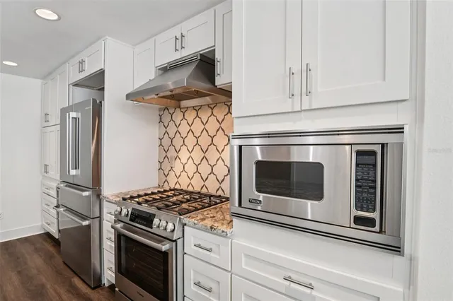 a kitchen with stainless steel appliances a stove and a microwave