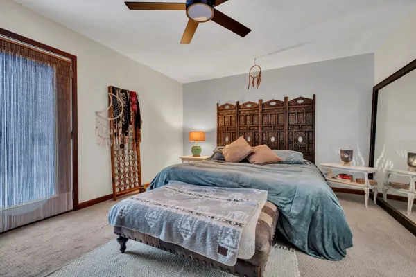 a spacious bedroom with a bed and a chandelier