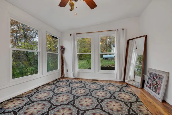 a view of a bedroom with wooden floor and a window