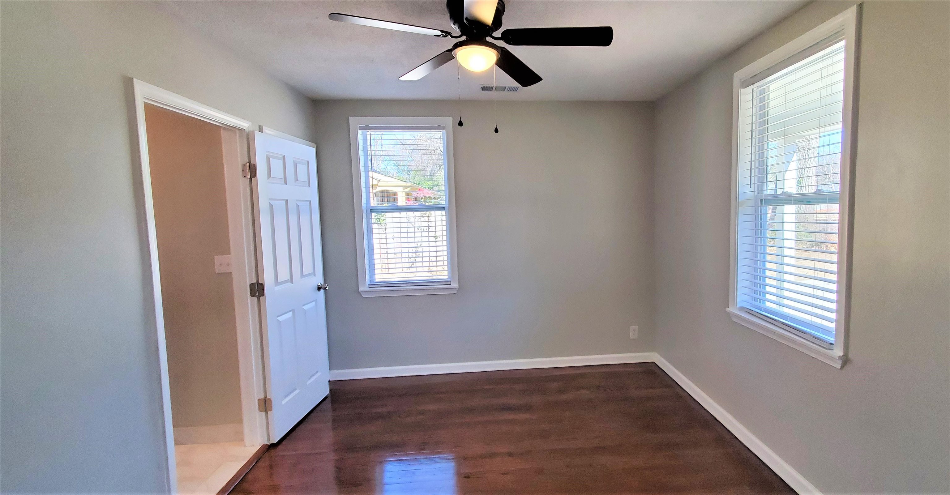 1077 Colonial Road Memphis, TN 38117 - Photo 12 of 20 a view of an empty room with a window and wooden floor