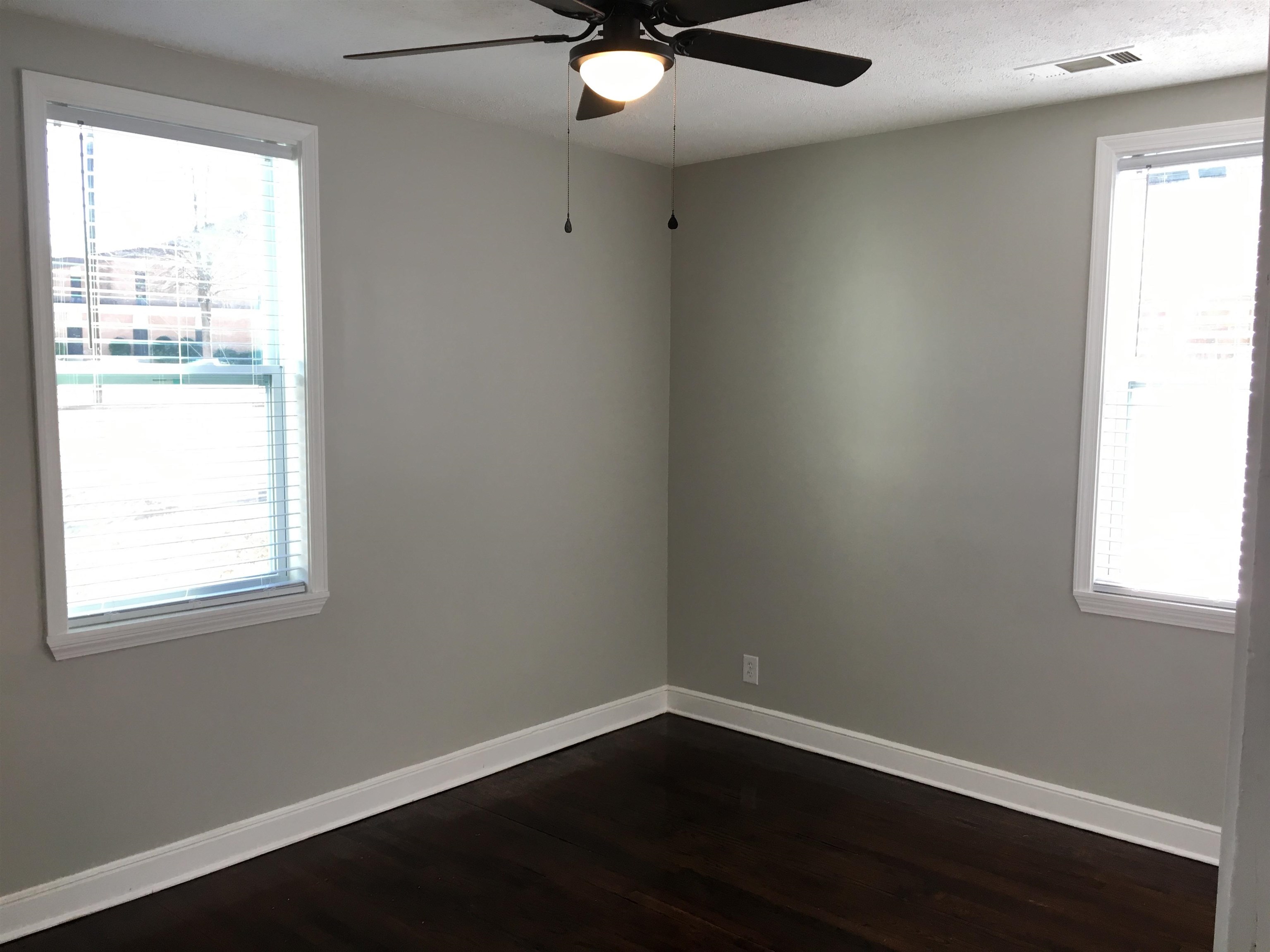 1077 Colonial Road Memphis, TN 38117 - Photo 16 of 20 an empty room with wooden floor and windows