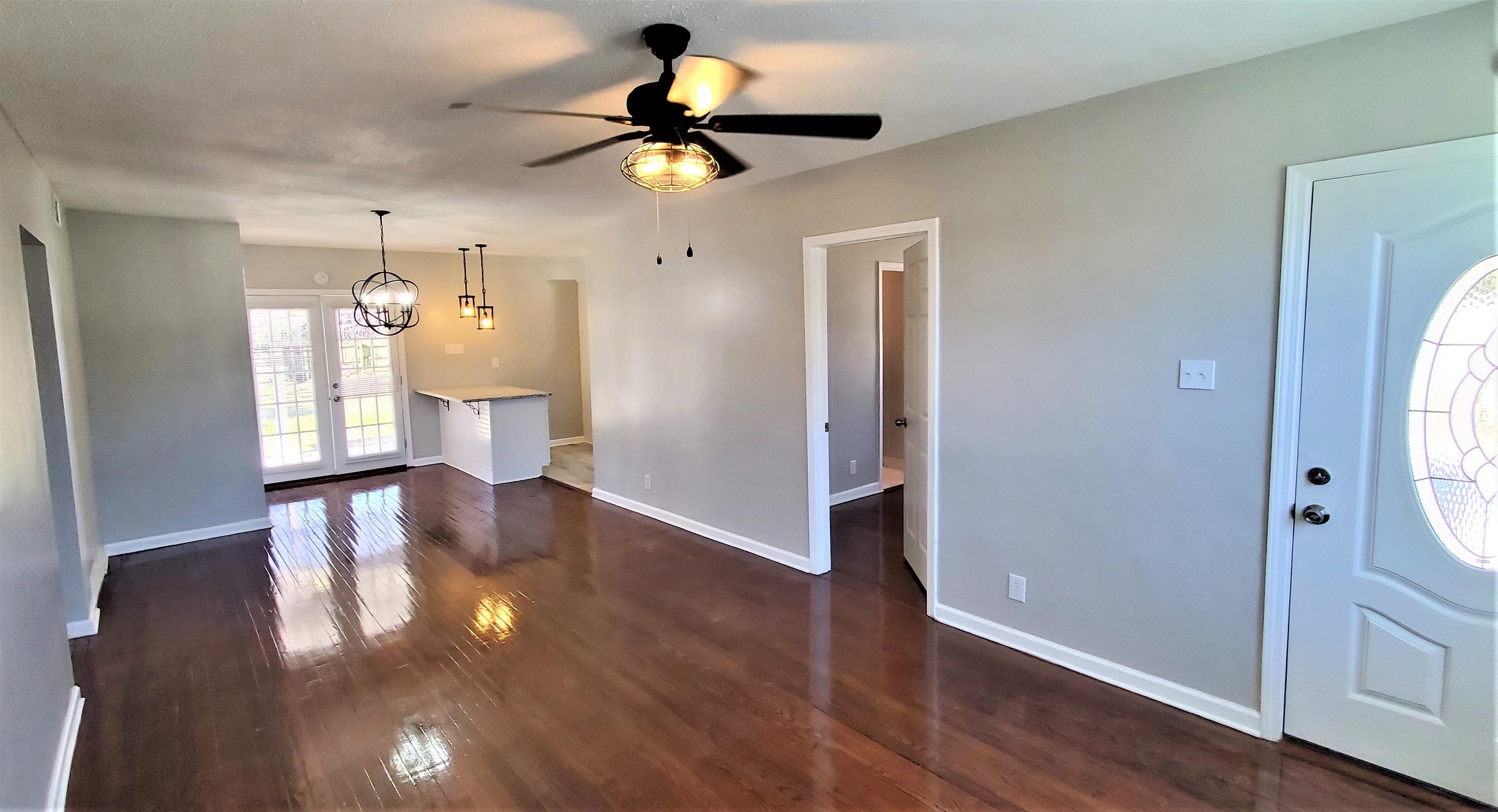 1077 Colonial Road Memphis, TN 38117 - Photo 3 of 20 a view of an empty room with wooden floor and a window