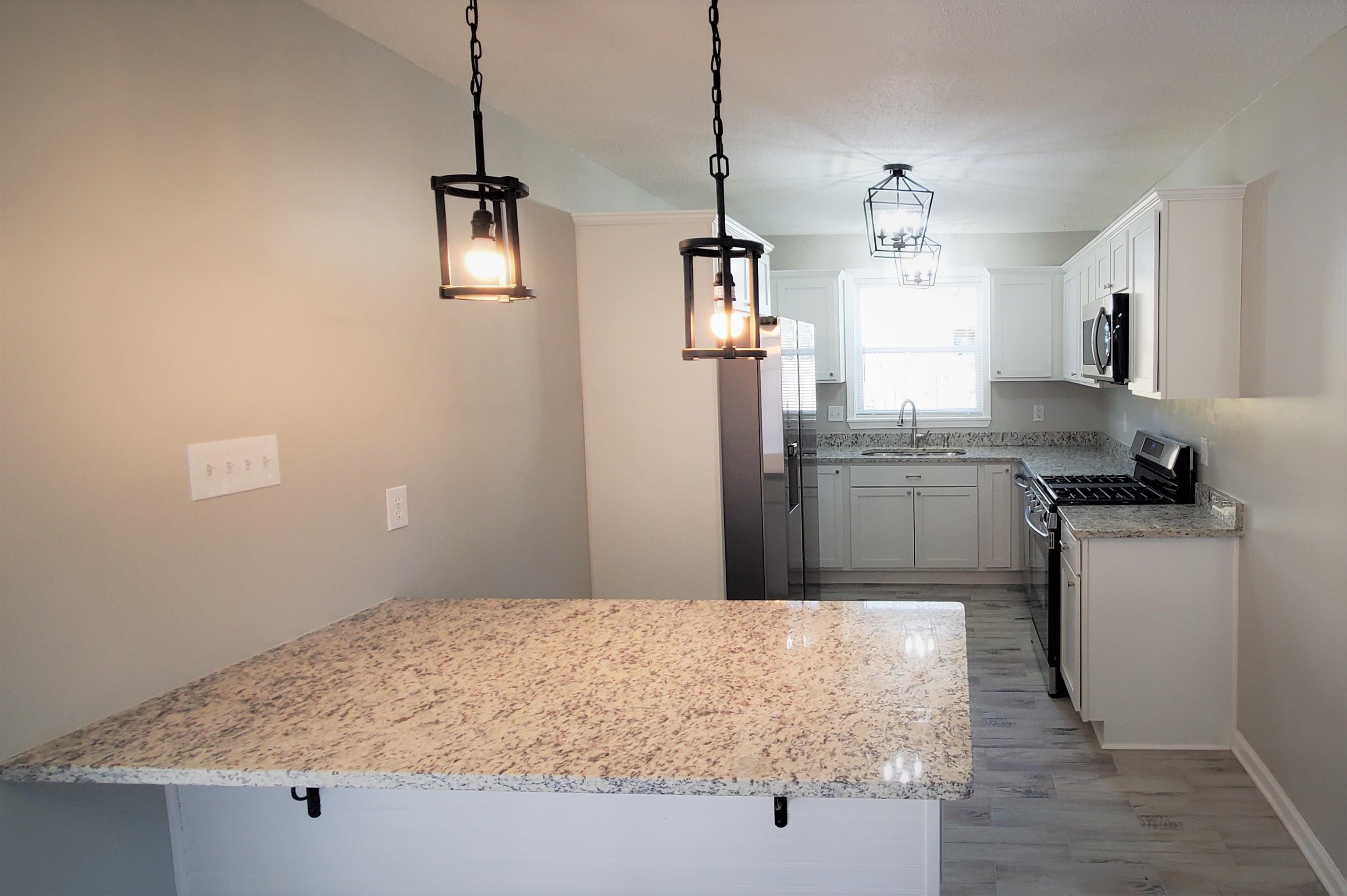 1077 Colonial Road Memphis, TN 38117 - Photo 6 of 20 a kitchen with kitchen island sink and refrigerator