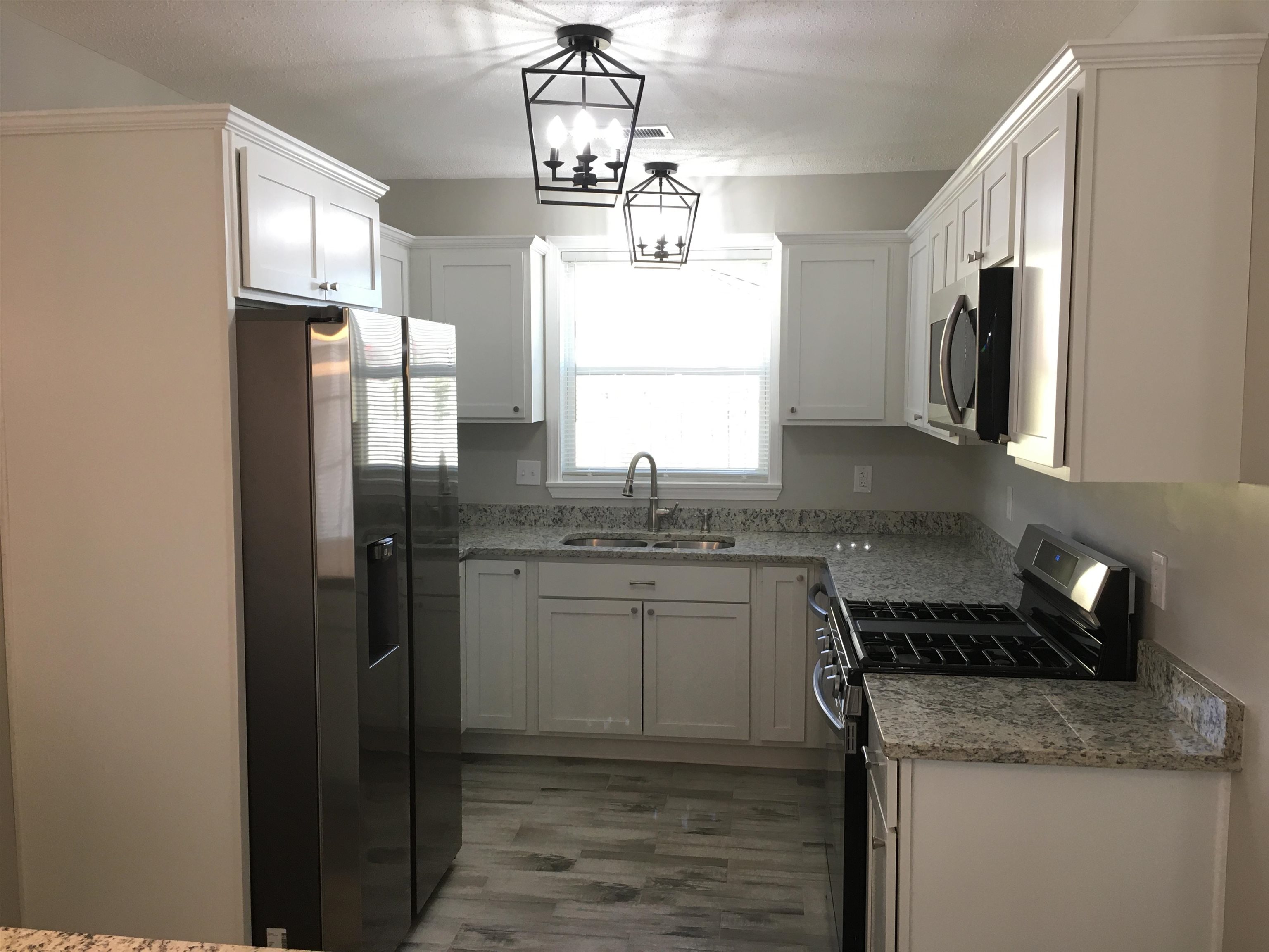 1077 Colonial Road Memphis, TN 38117 - Photo 7 of 20 a kitchen with stainless steel appliances granite countertop a sink stove and refrigerator