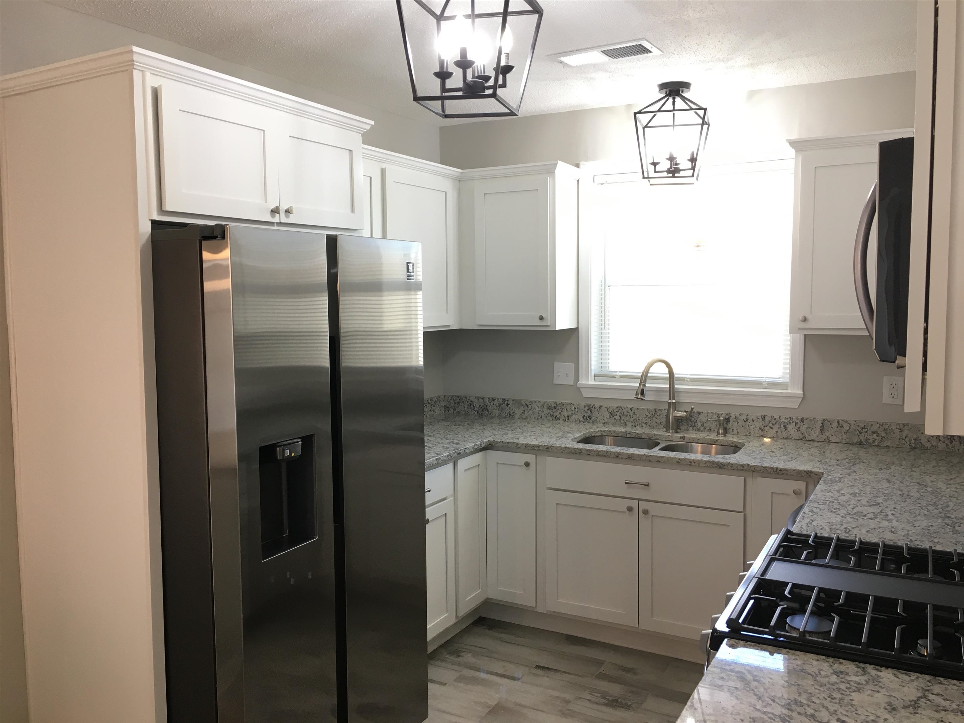 1077 Colonial Road Memphis, TN 38117 - Photo 9 of 20 a kitchen with stainless steel appliances granite countertop a refrigerator a sink a stove and island