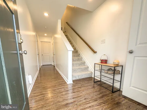 a view of a hallway with wooden floor and staircase