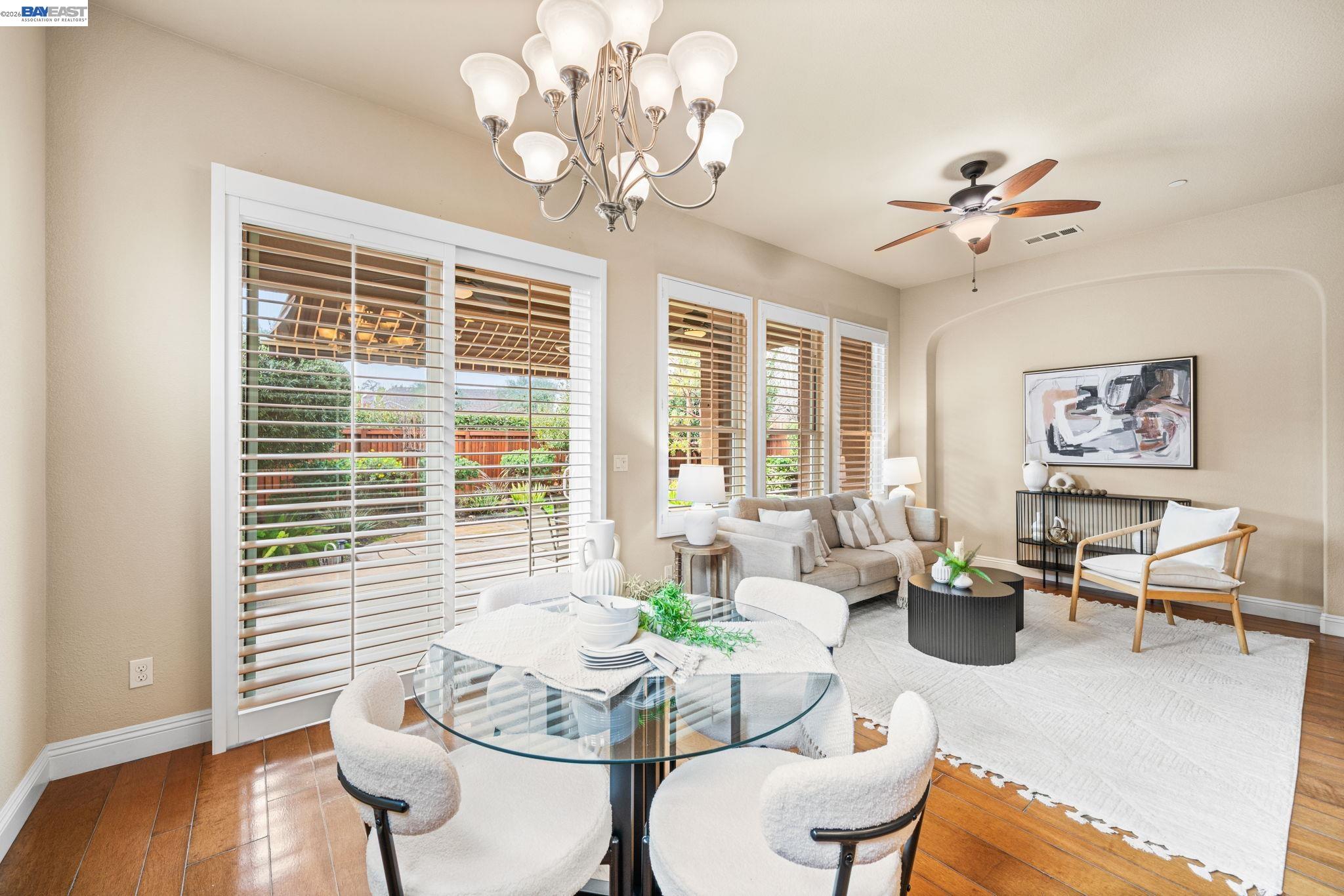 1033 Malbec Lane Brentwood, CA 94513 - Photo 16 of 37 a living room with couches chandelier and a dining table with wooden floor