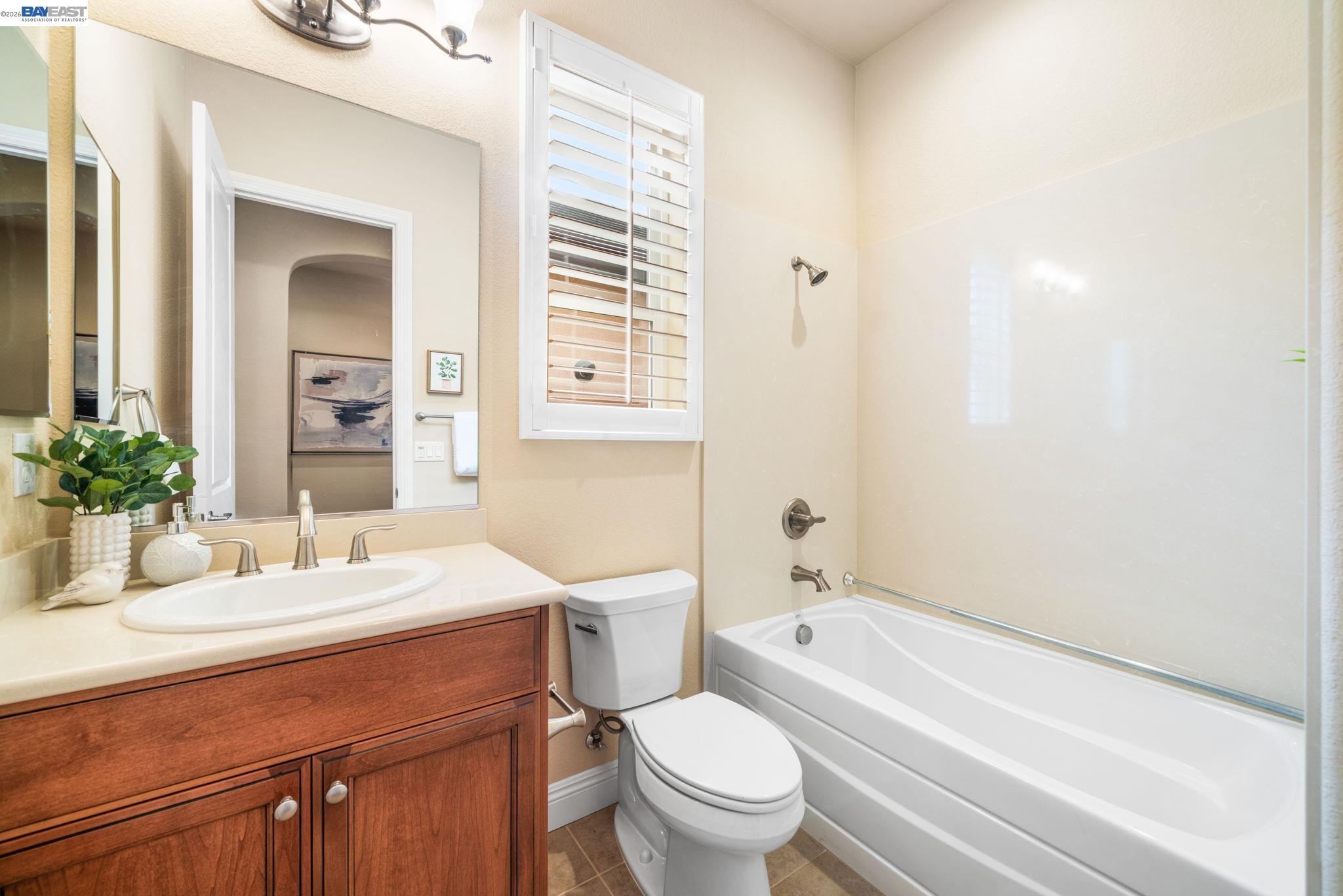 1033 Malbec Lane Brentwood, CA 94513 - Photo 5 of 37 a bathroom with a sink a toilet a mirror and shower