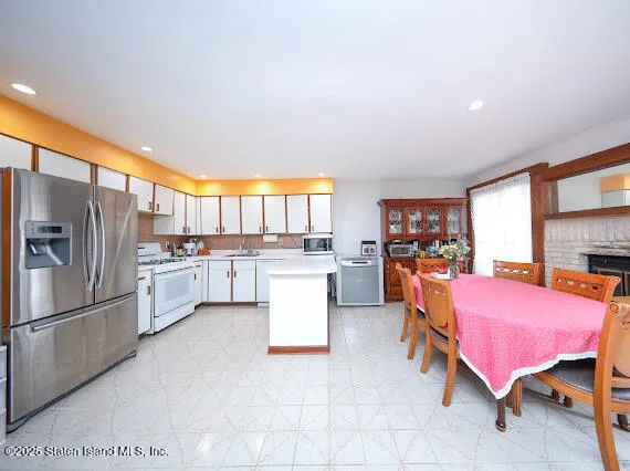 a kitchen with granite countertop a refrigerator and white cabinets