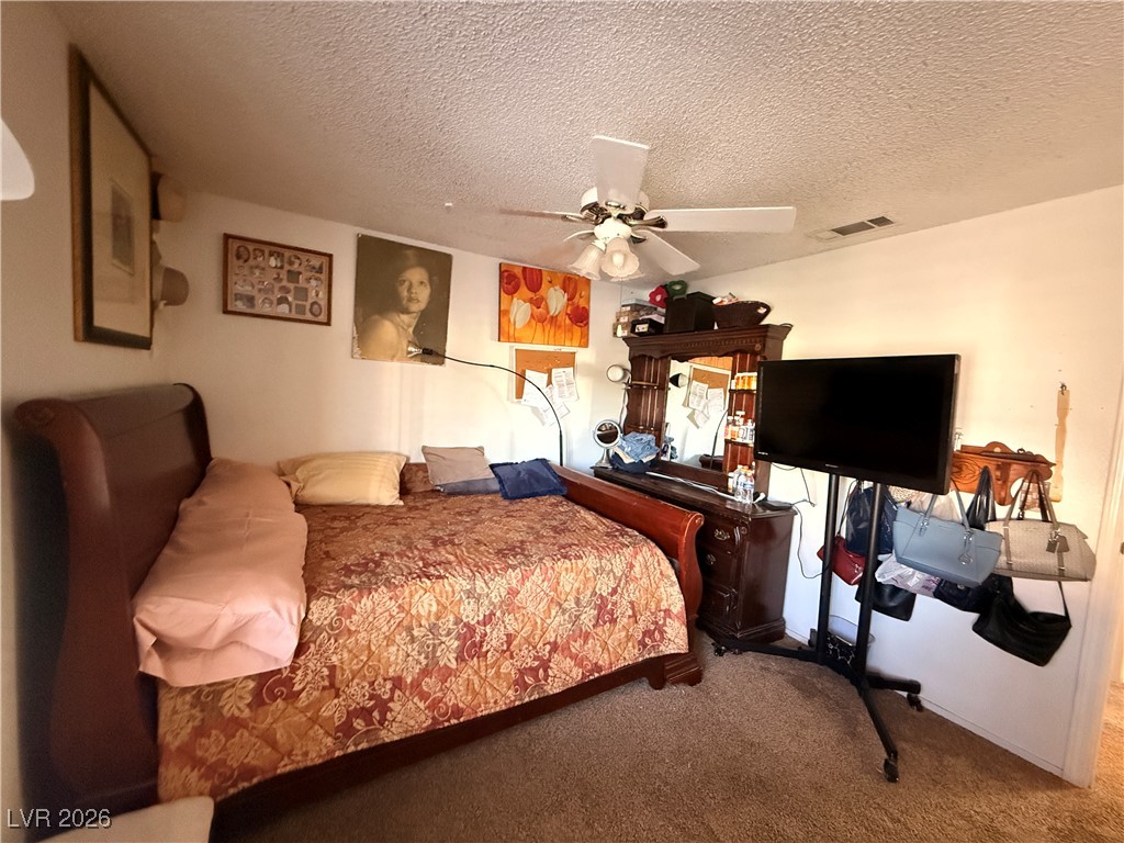 6425 West Eagle Point Road Las Vegas, NV 89108 - Photo 11 of 42 Carpeted bedroom with a textured ceiling and ceiling fan