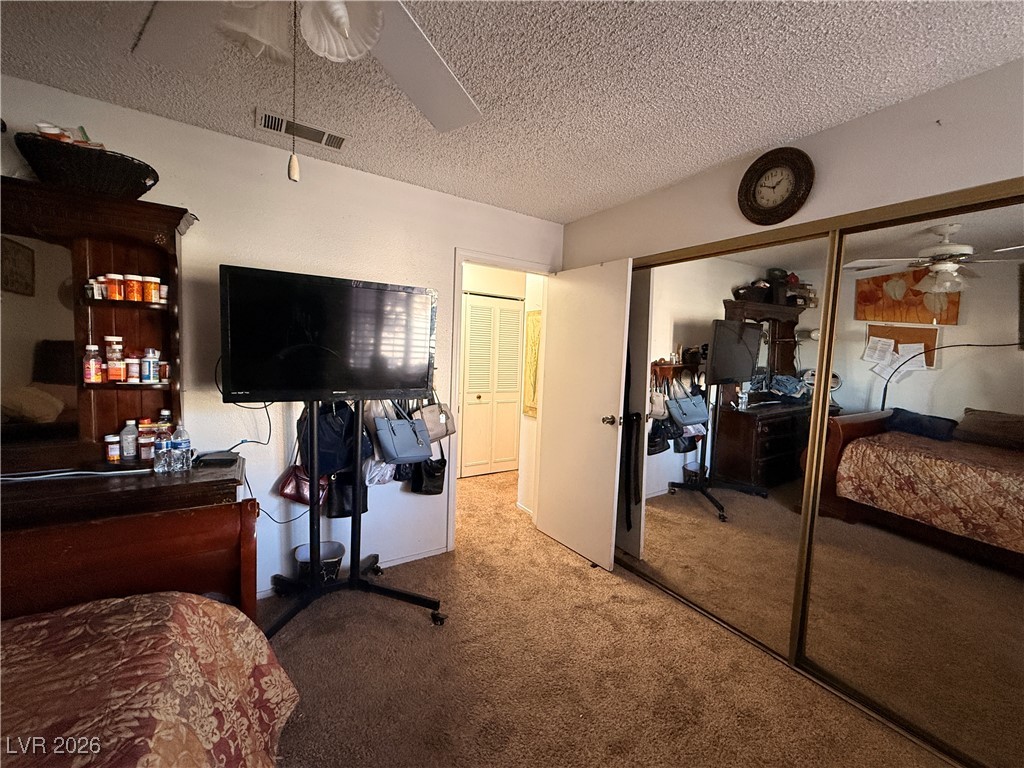 6425 West Eagle Point Road Las Vegas, NV 89108 - Photo 12 of 42 Bedroom with a ceiling fan, carpet floors, a closet, and a textured ceiling